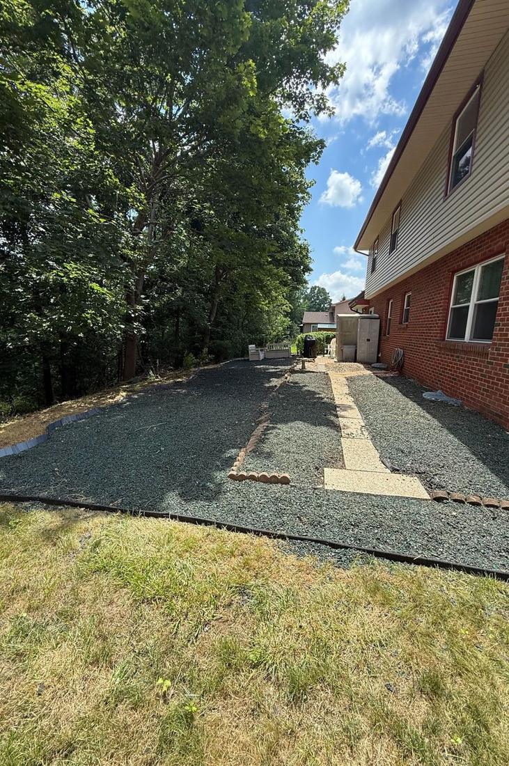 Expanded gravel side yard with a new paver walkway