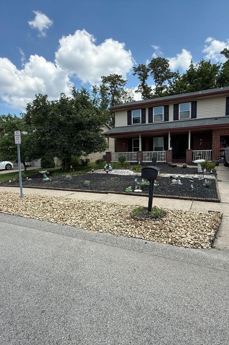 Fresh mulch bed and river rock border along a sidewalk