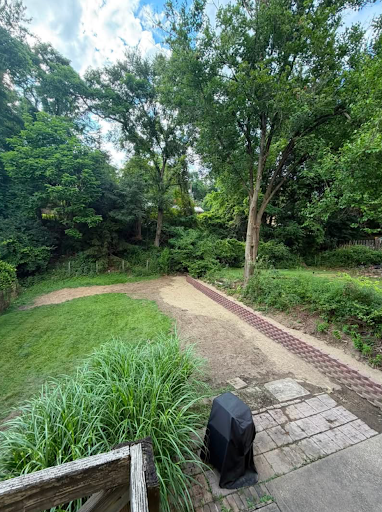 Regraded backyard with a new paver drainage channel running away from the patio